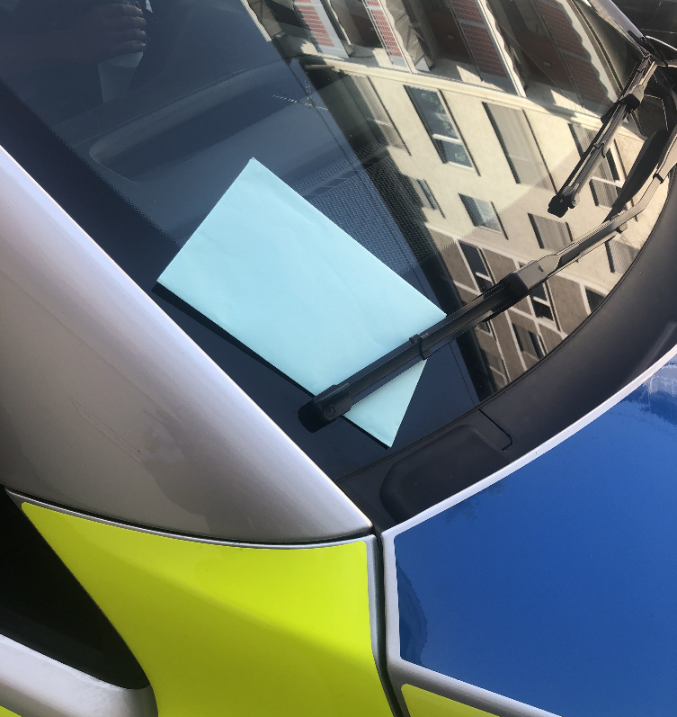 Dankesbrief an die Verkehrspolizei Stuttgart, angebracht an der Windschutzscheibe eines Streifenwagens.